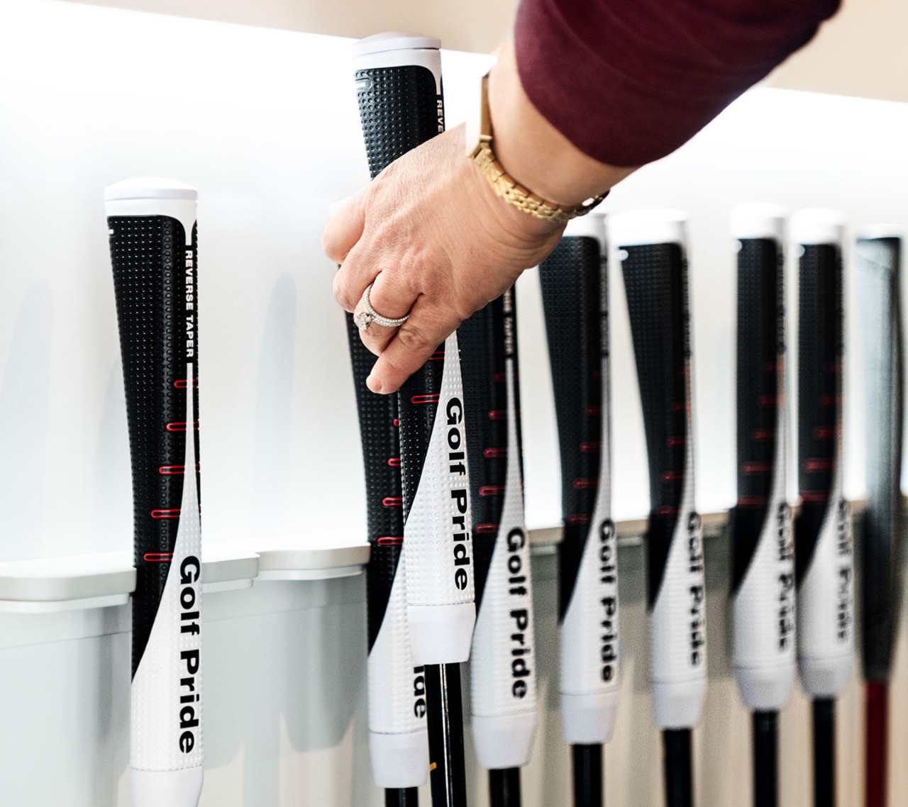 hand reaching for a putter reverse taper grip