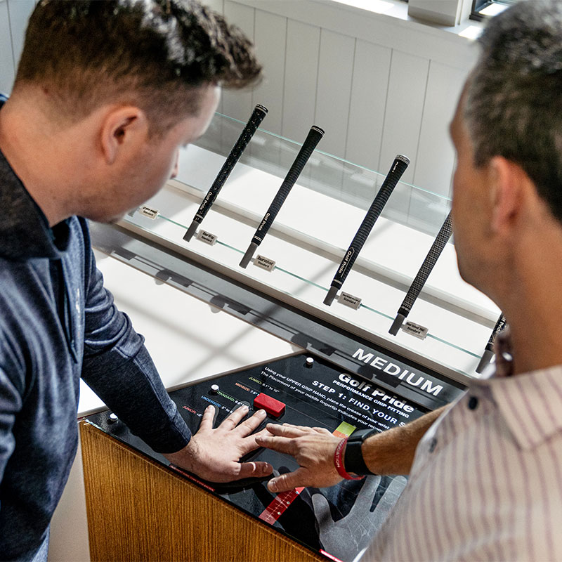 associate helping someone measure their hand for the right size grip