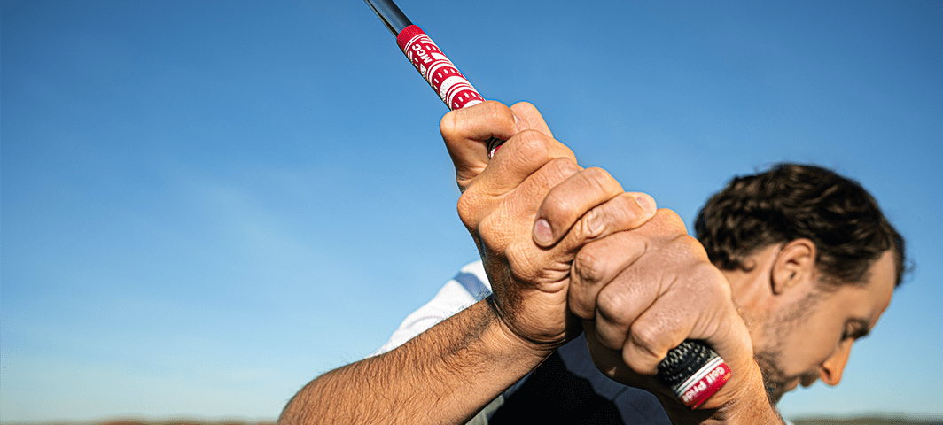 Close up of man's hands on a golf grip in his backswing