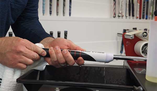 man regripping a reverse taper club