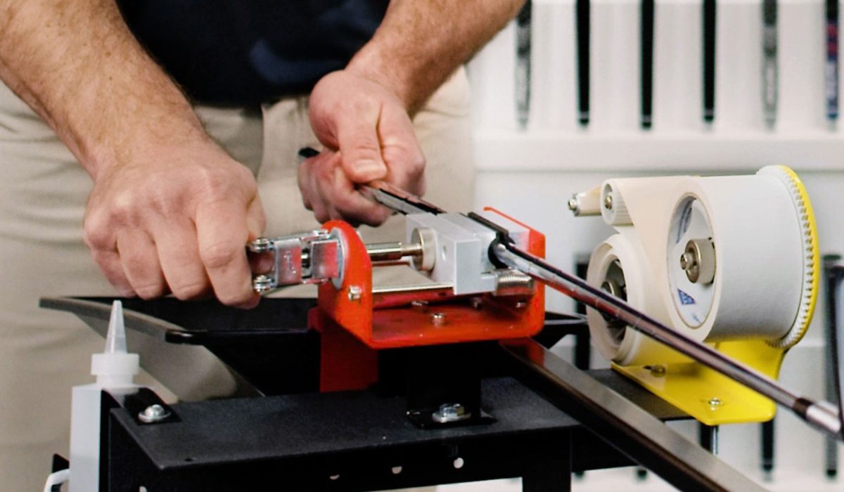 Profession regripping a club with a golf pride grip