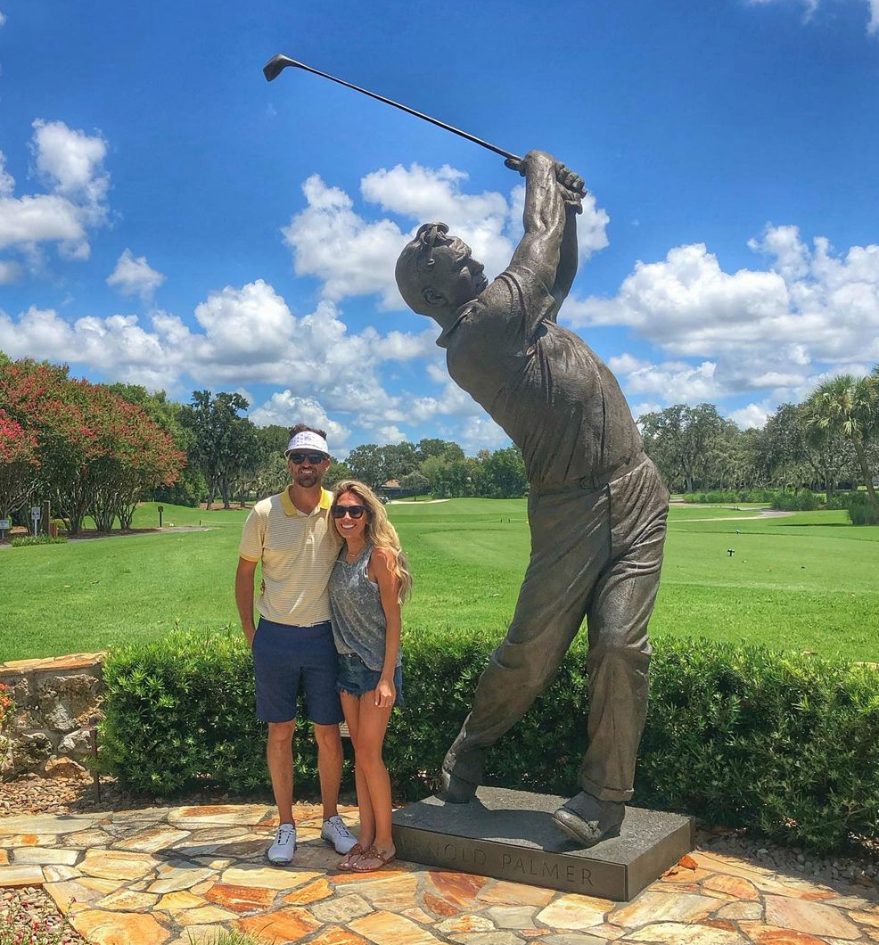 Bryan LaRoche and his wife next to an Arnold Palmer statue